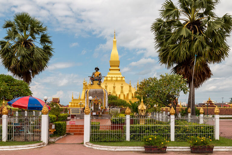 im Vordergrund die König Setthathirath Statue, dahinter der Phra That Luang